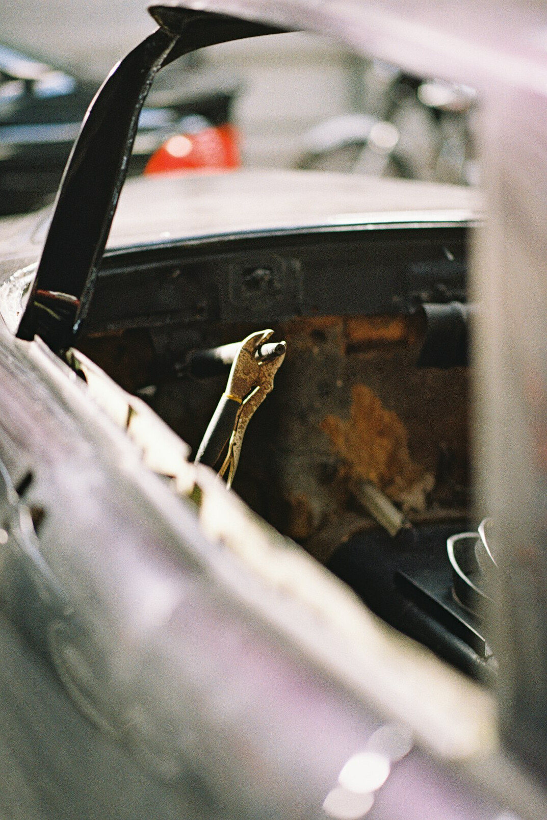 Mechanic inspecting the underside of a car in a workshop